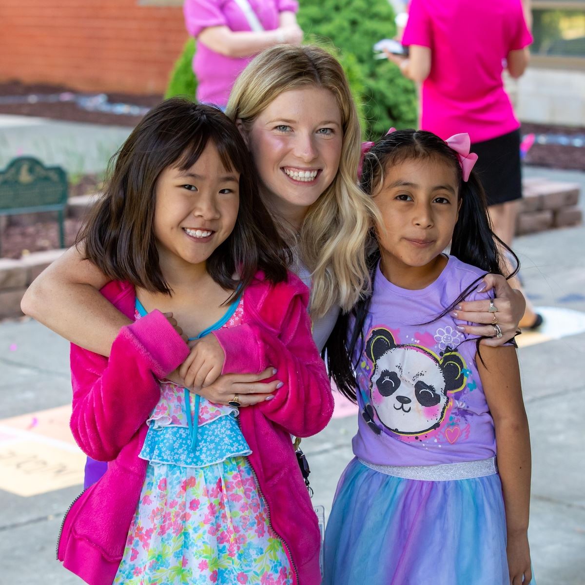  Coach Brinson hugs two students at her Teacher of the Year celebration